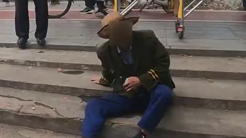 长沙枫林三路：老人手持酒瓶坐在街头 众人暖心救助